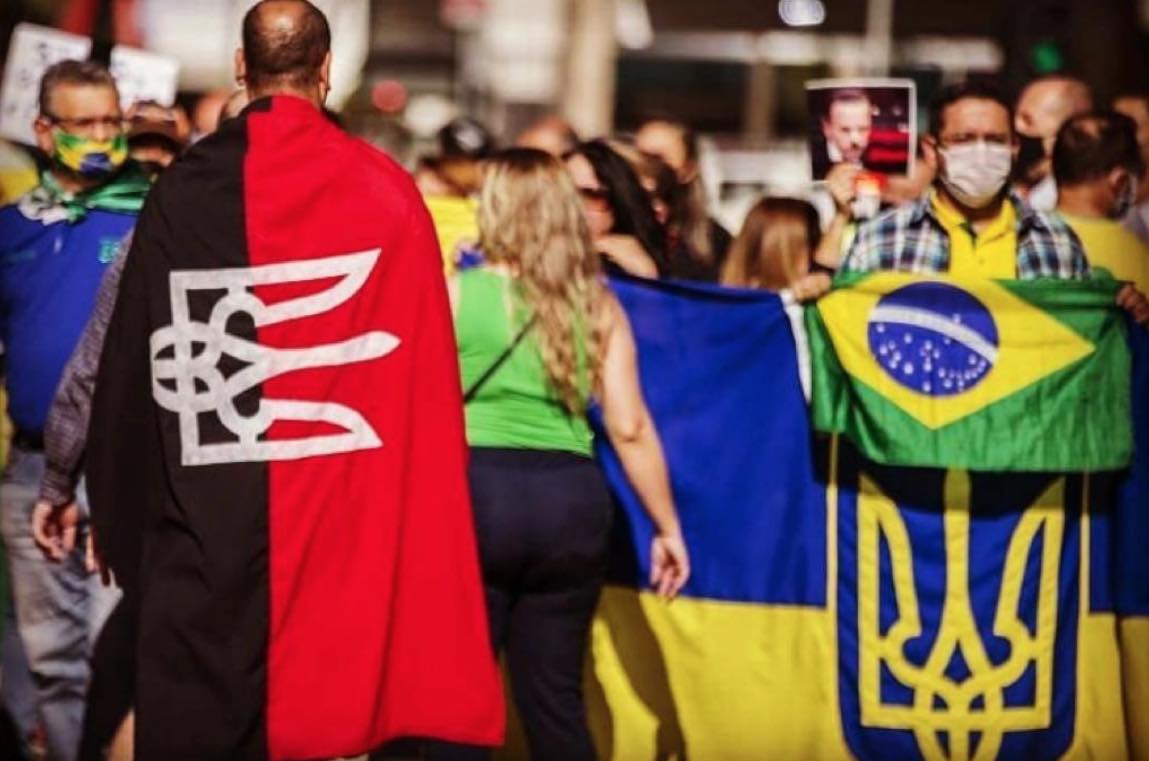 El influencer de extrema derecha Alex Silva, ex soldado y "policía auxiliar voluntario" en Kiev, envuelto en una bandera del Pravyi Sektor en una protesta de 2020 en Sao Paulo.