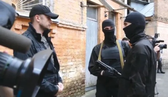 El teniente coronel Andriy Biletsky, policía ucraniano y oficial al mando del regimiento policial especial de Azov, con dos voluntarios enmascarados, junio de 2014.