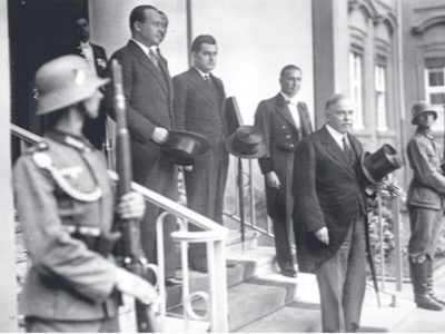 En 1937, el primer ministro de Canadá, William King, viaja a Berlín. Aquí ‎lo vemos a la salida de su encuentro con el Fuhrer Adolf Hitler, a quien comparó con Juana ‎de Arco, viéndolo como un “libertador de su pueblo”.‎