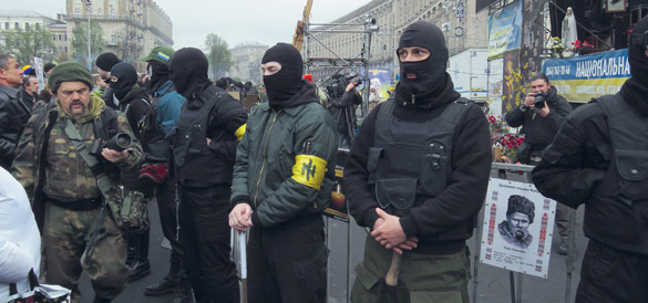 CC/Aimaina hikari Miembros de Patriotas de Ucrania haciendo guardia en un acto del Sector Derecho en el Euromaidán, Kiev, 13 de abril de 2014. Obsérvese la esvástica rebautizada en el brazalete amarillo de Azov.