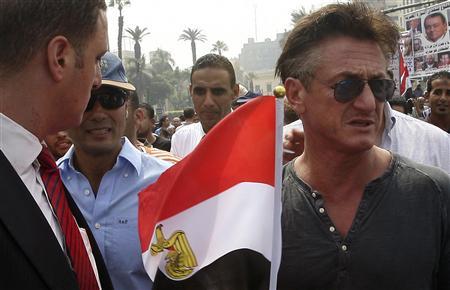 El actor y director estadounidense Sean Penn (R) sostiene una bandera de Egipto mientras camina con el actor egipcio Khaled al-Nabawi en la plaza Tahrir durante una protesta contra el consejo militar gobernante, después de las oraciones del viernes en El Cairo el 30 de septiembre de 2011. REUTERS/Stringer