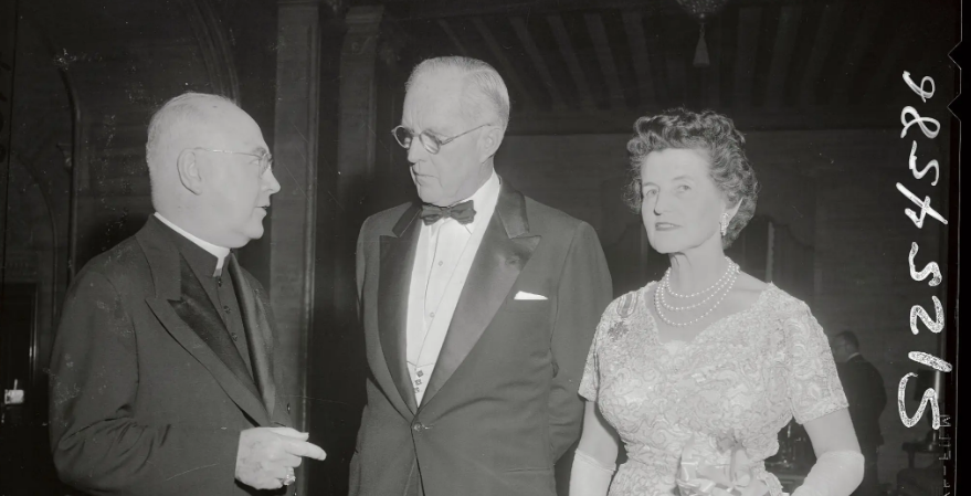 El Arzobispo de Nueva York y más tarde cardenal Francis Spellman (izquierda) aparece con el Sr. Joseph P. Kennedy y la y la Sra. Rose Fitzgerald Kennedy en la 18ª cena anual del club de campeones de la Organización Católica de Jóvenes (CYO) en el Hotel Park Lane. La Sra. Kennedy, condesa papal [https://motherhoodinpointoffact.com/rose-kennedy-or-what-it-takes-to-be-honored-with-the-title-of-papal-countess-for-exemplary-motherhood/] y esposa del ex embajador de EE.UU. en la corte de St. James [https://www.historiamag.com/the-ambassador-e-by-susan-ronald/] (la corte real del Soberano del Reino Unido), se convirtió en la primera mujer en recibir el premio Medalla de Oro de la CYO por su historial de servicio a la juventud. El Sr. Kennedy formó parte de la junta directiva de la CYO. Debido a su estrecha amistad con Francis Spellman, Joseph Kennedy fue investido caballero de la Soberana Orden Militar de Malta.