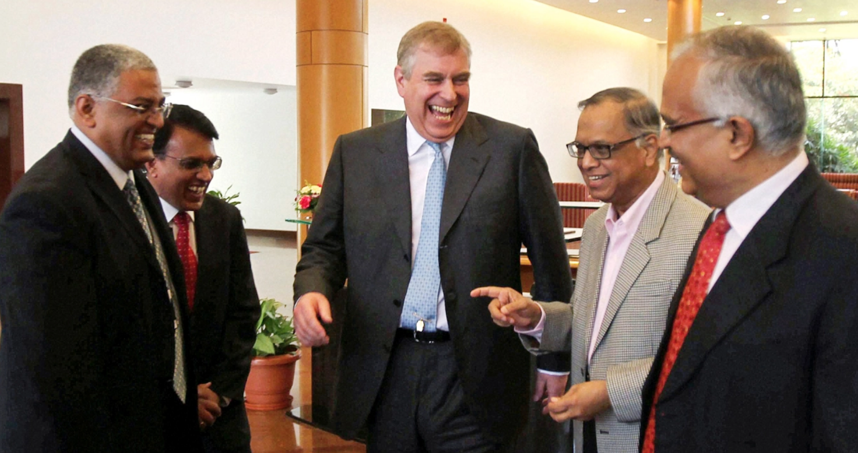 El suegro de Rishi Sunak, Narayana Murthy (segundo de derecha a izquierda), ríe con el príncipe Andrés de Gran Bretaña, acusado de pedofilia (al centro), en la sede de Infosys en Bangalore, India, en 2012. Foto | AP